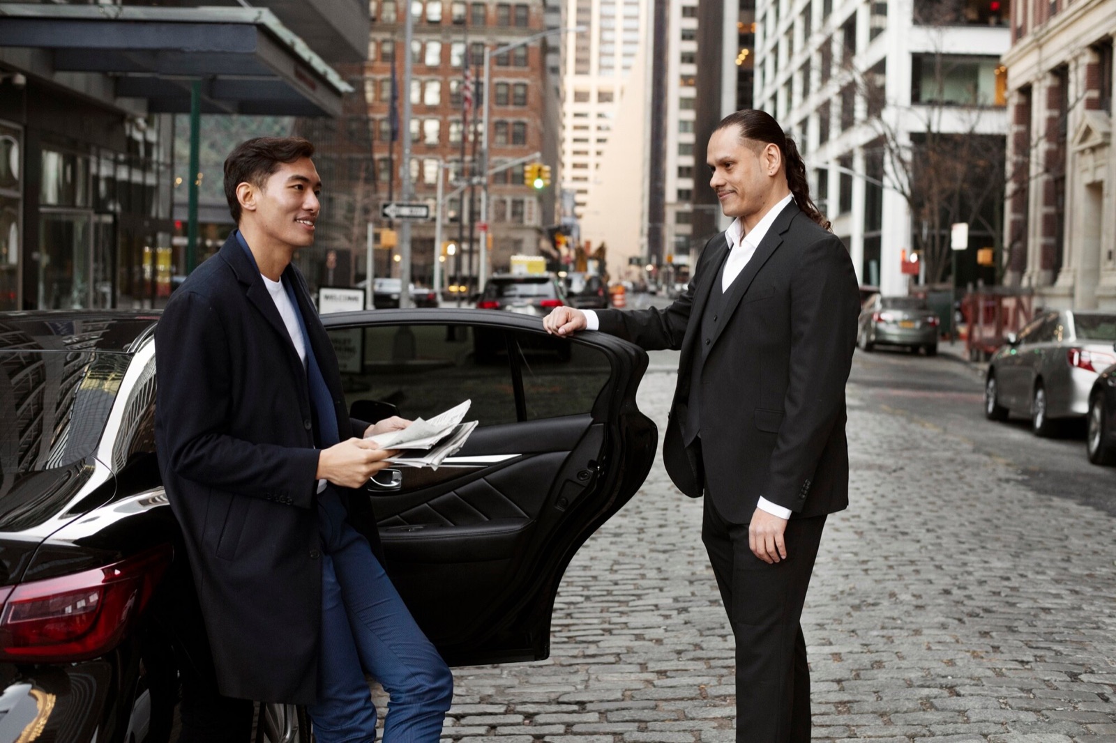 Chauffeur holding the car door open for a guest arriving at a film premiere